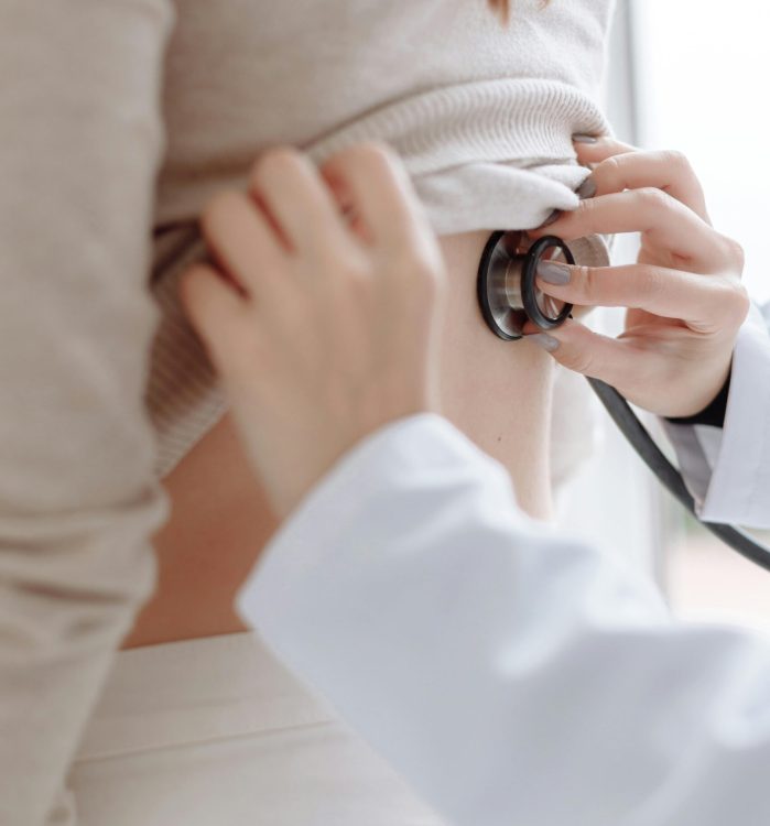 Close-up of doctor using stethoscope on patient's back during medical examination.